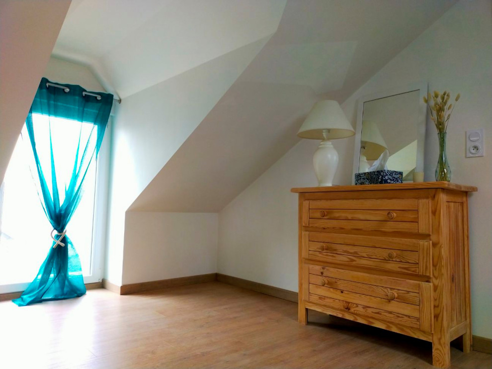 Ispirazione per una camera da letto stile loft design di medie dimensioni con pareti verdi, parquet chiaro e travi a vista