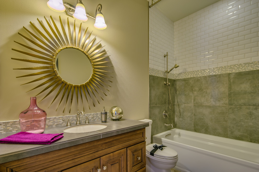 Inspiration for a mid-sized traditional bathroom in Portland with an undermount sink, raised-panel cabinets, medium wood cabinets, tile benchtops, an alcove tub, an alcove shower, a two-piece toilet, gray tile, porcelain tile, beige walls and ceramic floors.