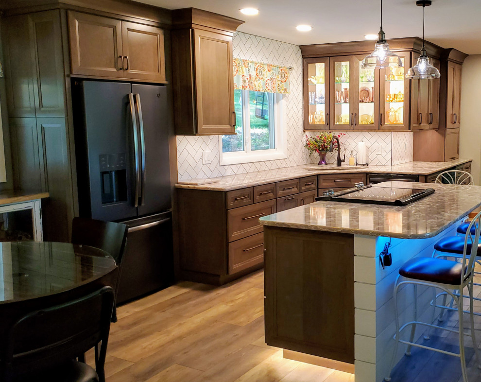 Mid-sized transitional vinyl floor and beige floor open concept kitchen photo with an undermount sink, recessed-panel cabinets, gray cabinets, quartz countertops, white backsplash, subway tile backsplash, black appliances, an island and beige countertops