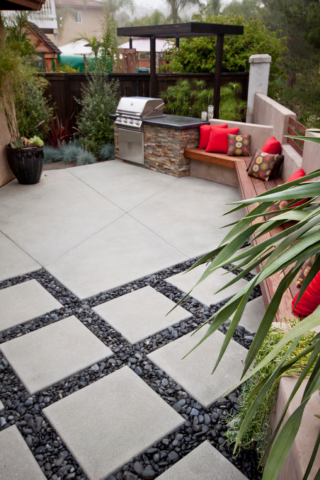 This is an example of a small contemporary backyard patio in San Diego with concrete pavers, no cover and an outdoor kitchen.