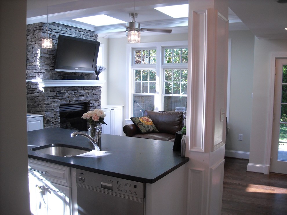 Inspiration for a mid-sized transitional l-shaped medium tone wood floor and brown floor kitchen remodel in Dallas with an undermount sink, raised-panel cabinets, white cabinets, stainless steel appliances, an island and soapstone countertops
