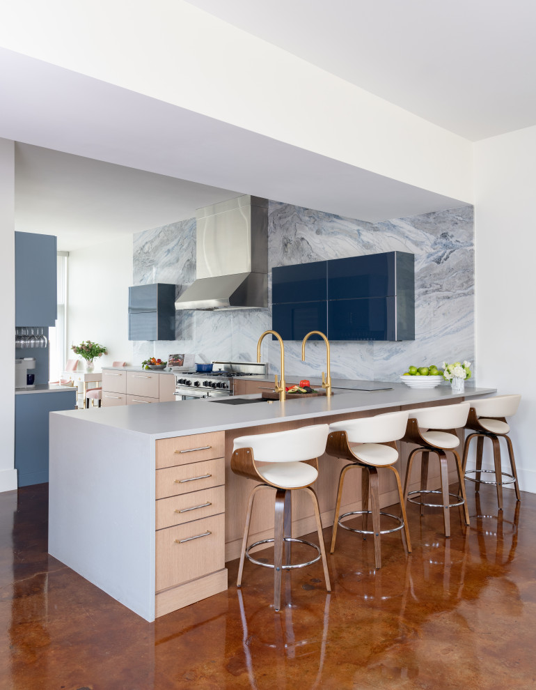 Modern inredning av ett vit vitt kök och matrum, med släta luckor, blå skåp, blått stänkskydd, stänkskydd i sten och en köksö