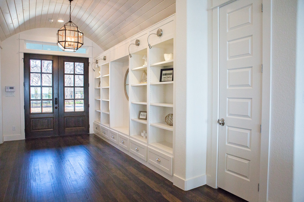 Example of a large beach style dark wood floor and brown floor entryway design in Dallas with white walls and a dark wood front door