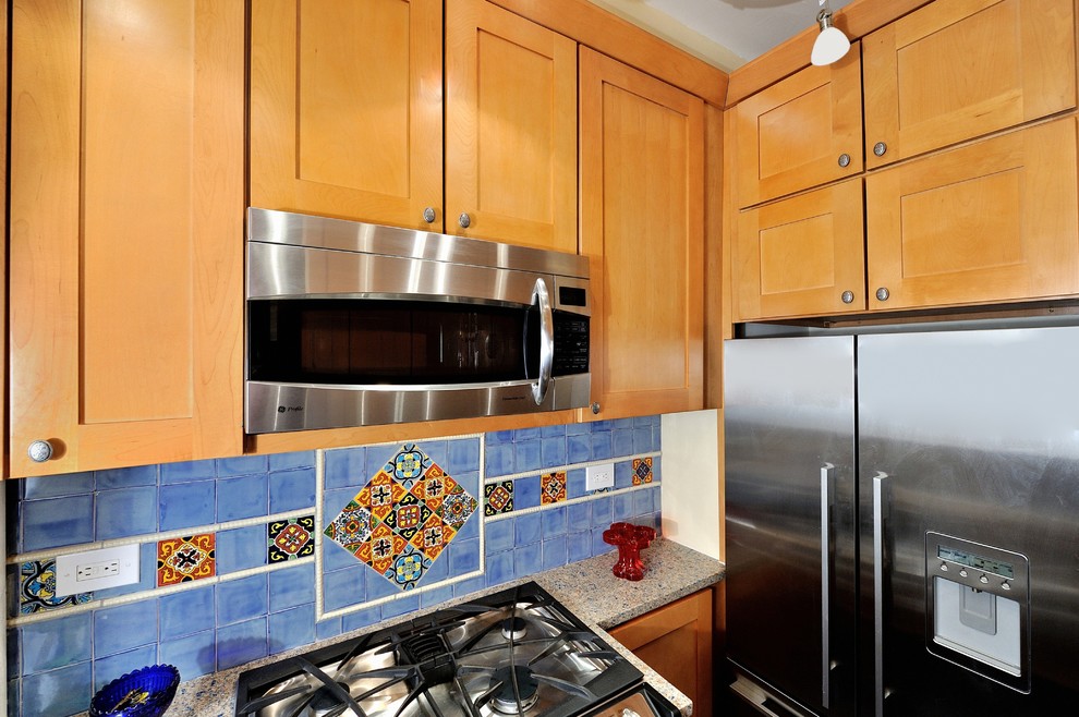 Inspiration for a small mediterranean u-shaped separate kitchen in New York with a single-bowl sink, raised-panel cabinets, light wood cabinets, blue splashback, ceramic splashback, stainless steel appliances, recycled glass benchtops and porcelain floors.