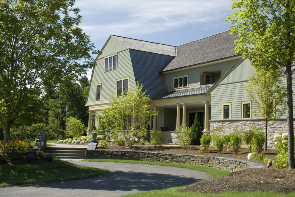 This is an example of a large traditional three-storey green exterior in Other with wood siding and a gambrel roof.