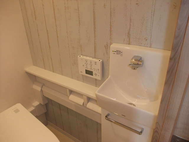 トイレは、木目のアクセントクロス。 country-bagno-di-servizio