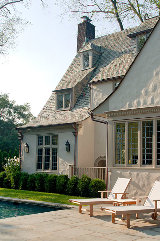 Photo of a mid-sized traditional two-storey stucco beige house exterior in New York with a shingle roof.