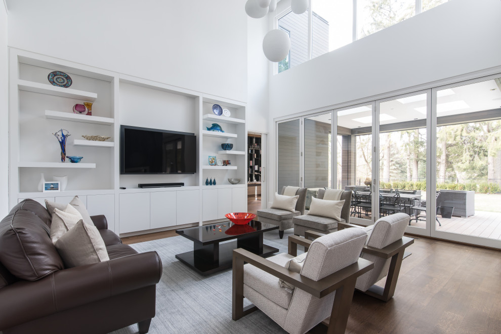 Contemporary open plan living room in Toronto with white walls, dark hardwood flooring, no fireplace, a wall mounted tv and brown floors.