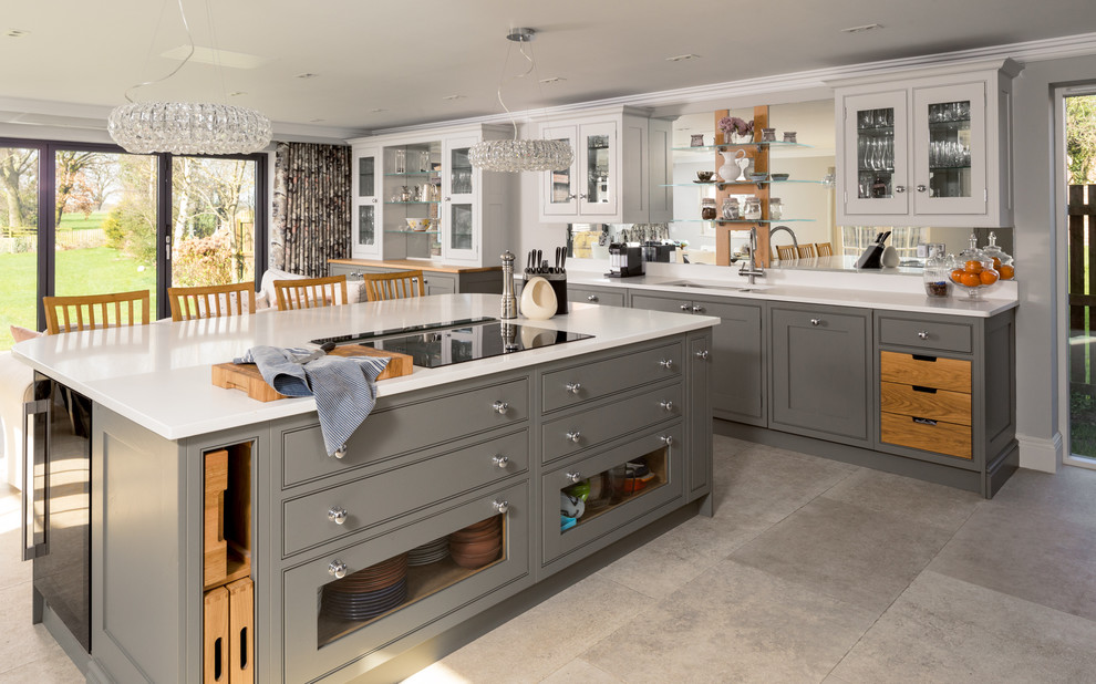 Photo of a large traditional u-shaped open plan kitchen in Manchester with a drop-in sink, glass-front cabinets, grey cabinets, granite benchtops, white splashback, marble splashback, stainless steel appliances, porcelain floors, multiple islands, grey floor and white benchtop.