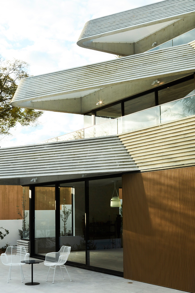 Modern three-storey grey house exterior in Sydney with mixed siding and a flat roof.