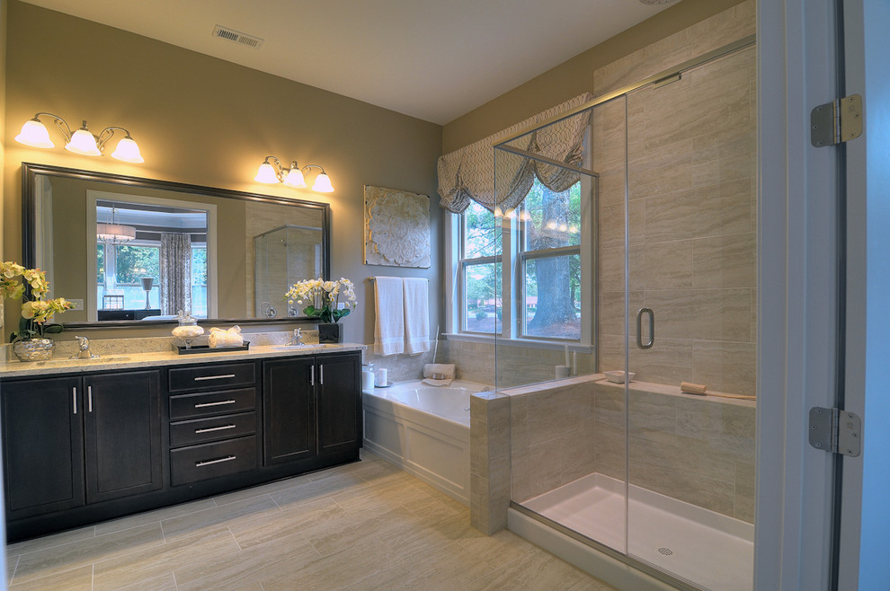 Photo of a large contemporary master bathroom in Charlotte with recessed-panel cabinets, dark wood cabinets, granite benchtops, beige tile, ceramic tile, beige walls and porcelain floors.