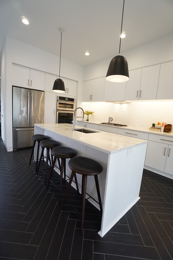 Photo of a small modern l-shaped kitchen in Richmond with an undermount sink, flat-panel cabinets, white cabinets, quartz benchtops, white splashback, ceramic splashback, stainless steel appliances, ceramic floors, with island, black floor and white benchtop.