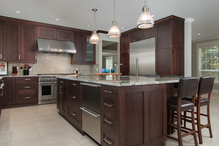Open concept kitchen - mid-sized transitional l-shaped ceramic tile and beige floor open concept kitchen idea in Seattle with an undermount sink, shaker cabinets, dark wood cabinets, granite countertops, gray backsplash, ceramic backsplash, stainless steel appliances and an island