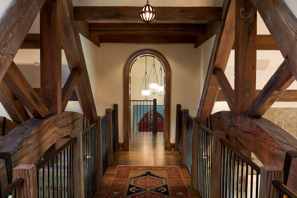 Photo of a large country hallway in Other with beige walls and dark hardwood floors.