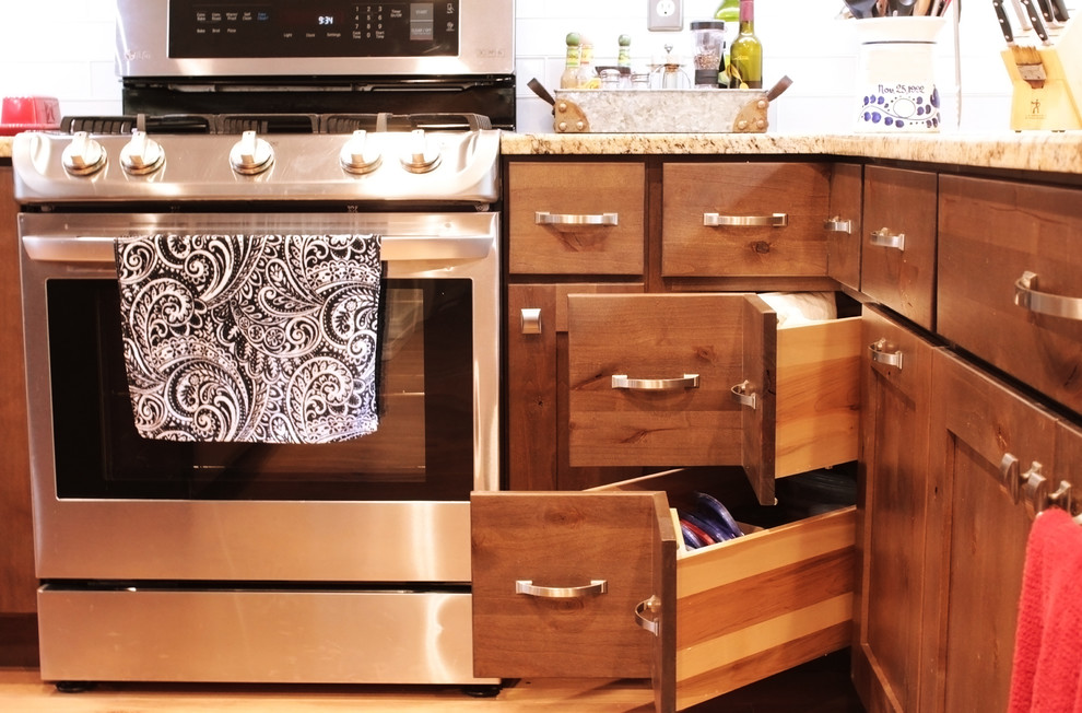 Inspiration for a large rustic u-shaped light wood floor and brown floor open concept kitchen remodel in Boise with an undermount sink, shaker cabinets, brown cabinets, granite countertops, white backsplash, glass tile backsplash, stainless steel appliances and an island
