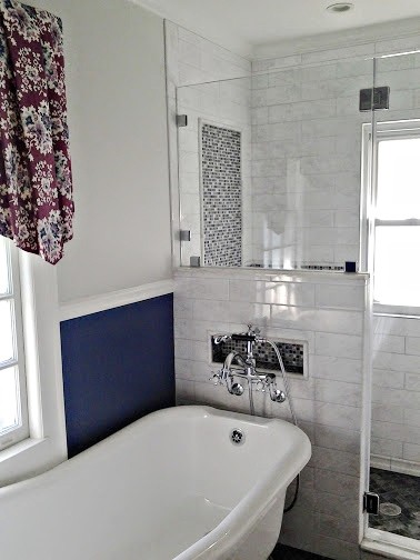 Photo of a mid-sized transitional master bathroom in New York with a console sink, a claw-foot tub, an alcove shower, a wall-mount toilet, white tile, ceramic tile, blue walls and marble floors.