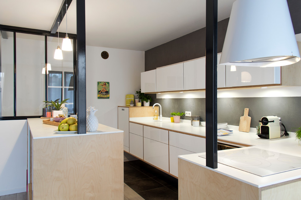 This is an example of a mid-sized scandinavian l-shaped open plan kitchen in Other with an integrated sink, beaded inset cabinets, light wood cabinets, solid surface benchtops, white splashback, white appliances, ceramic floors, with island and grey floor.