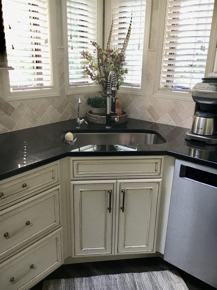 Inspiration for a large transitional u-shaped laminate floor and gray floor eat-in kitchen remodel with an undermount sink, recessed-panel cabinets, white cabinets, granite countertops, white backsplash, ceramic backsplash, stainless steel appliances, an island and black countertops