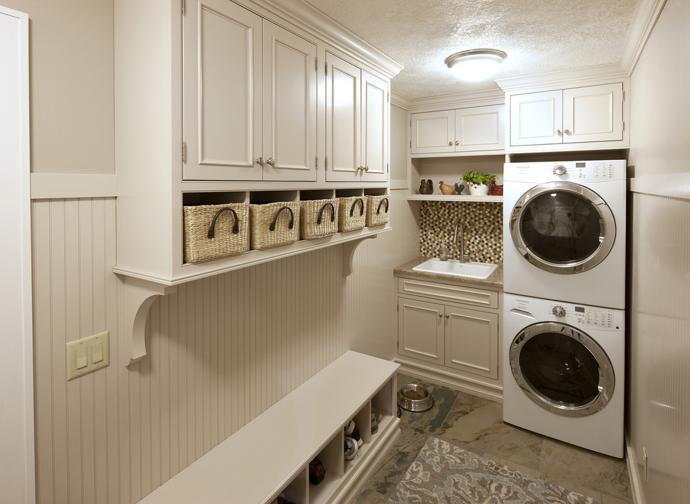 Small contemporary l-shaped utility room in DC Metro with a drop-in sink, beaded inset cabinets, white cabinets, quartz benchtops, beige walls, porcelain floors, a stacked washer and dryer and beige floor.