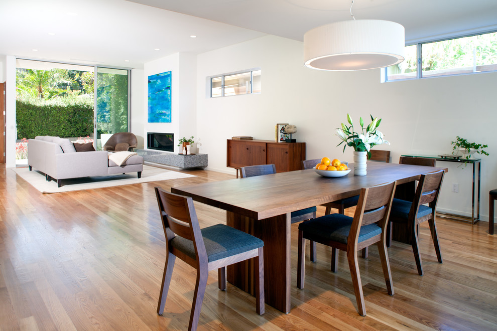 Inspiration for a contemporary dining room in Los Angeles with white walls and dark hardwood floors.