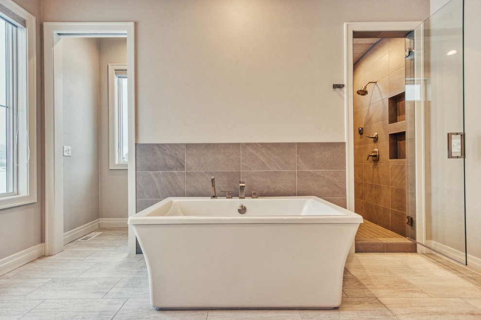 Large transitional master gray tile and ceramic tile ceramic tile and gray floor freestanding bathtub photo with shaker cabinets, white cabinets, an urinal, gray walls, an undermount sink, quartz countertops, a hinged shower door and white countertops