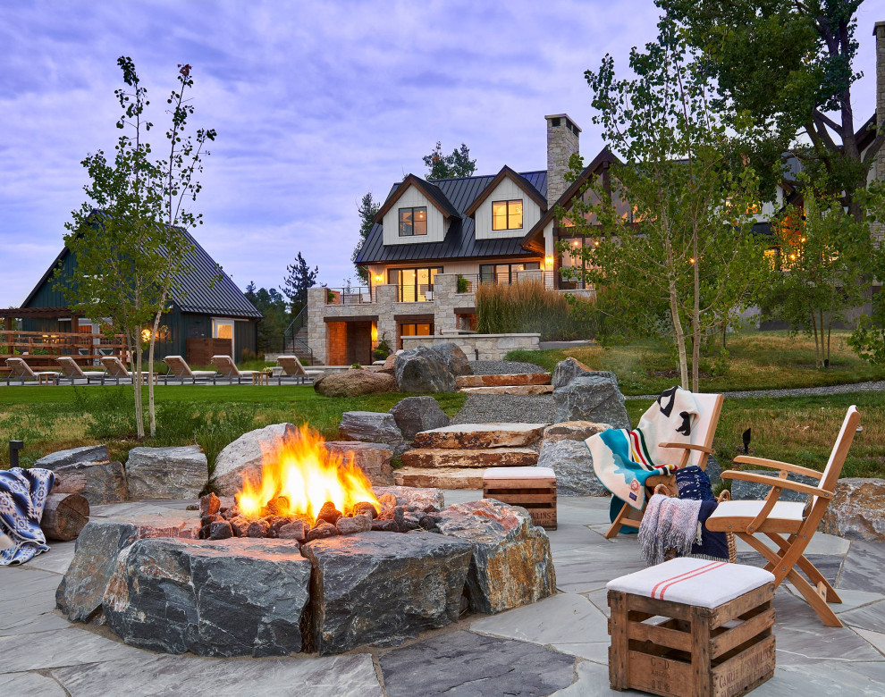 This is an example of an expansive country backyard patio in Denver with a fire feature.