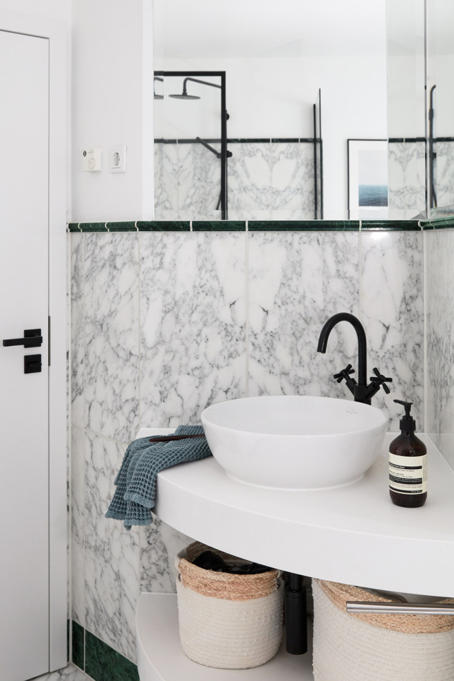 Foto på ett litet funkis vit badrum, med en hörndusch, en toalettstol med separat cisternkåpa, svart och vit kakel, marmorkakel, vita väggar, ett fristående handfat, bänkskiva i akrylsten och med dusch som är öppen
