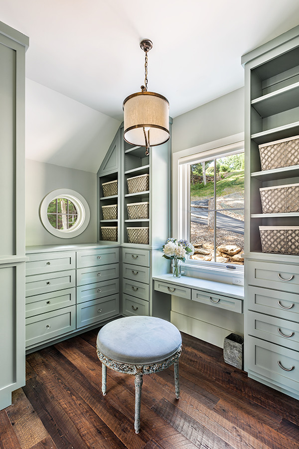 Photo of a large country gender-neutral dressing room in Other with shaker cabinets, green cabinets and dark hardwood floors.