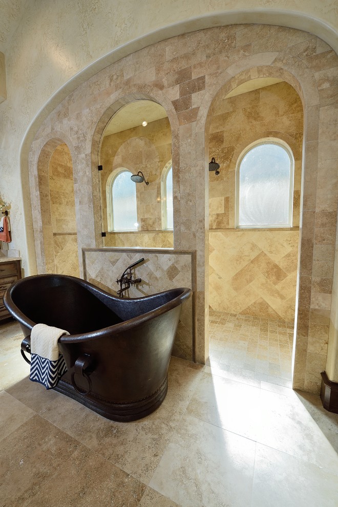 Large mediterranean master bathroom in Houston with raised-panel cabinets, medium wood cabinets, a freestanding tub, a double shower, beige tile, ceramic tile, beige walls, travertine floors, an undermount sink, marble benchtops, beige floor and an open shower.