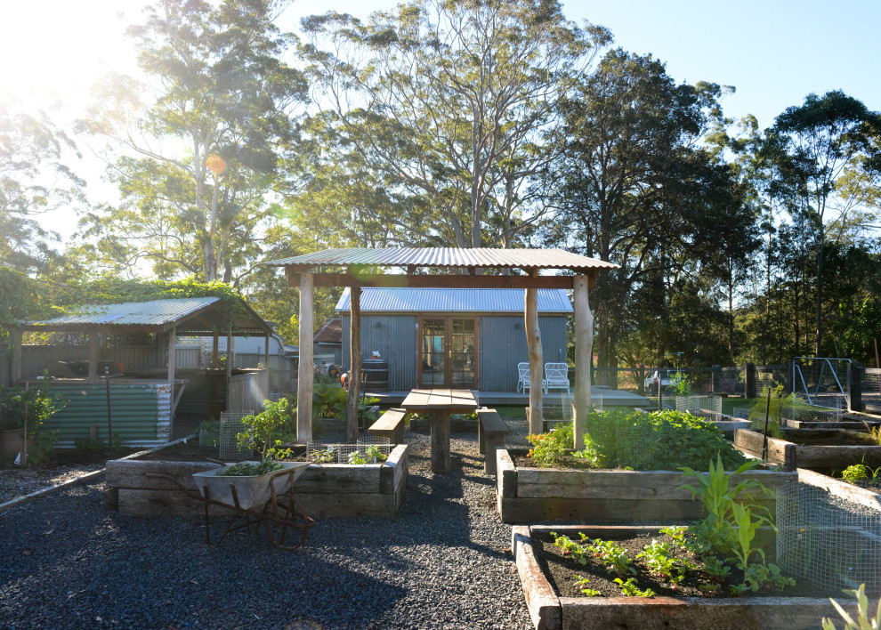 This is an example of a large farmhouse partial sun backyard gravel and wood fence vegetable garden landscape in Central Coast for spring.