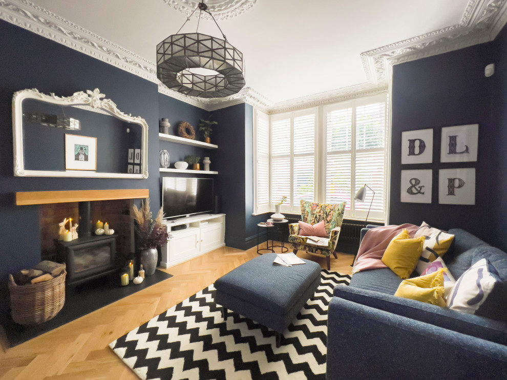 Idées déco pour un salon scandinave de taille moyenne et fermé avec un mur bleu, un poêle à bois et un téléviseur encastré.