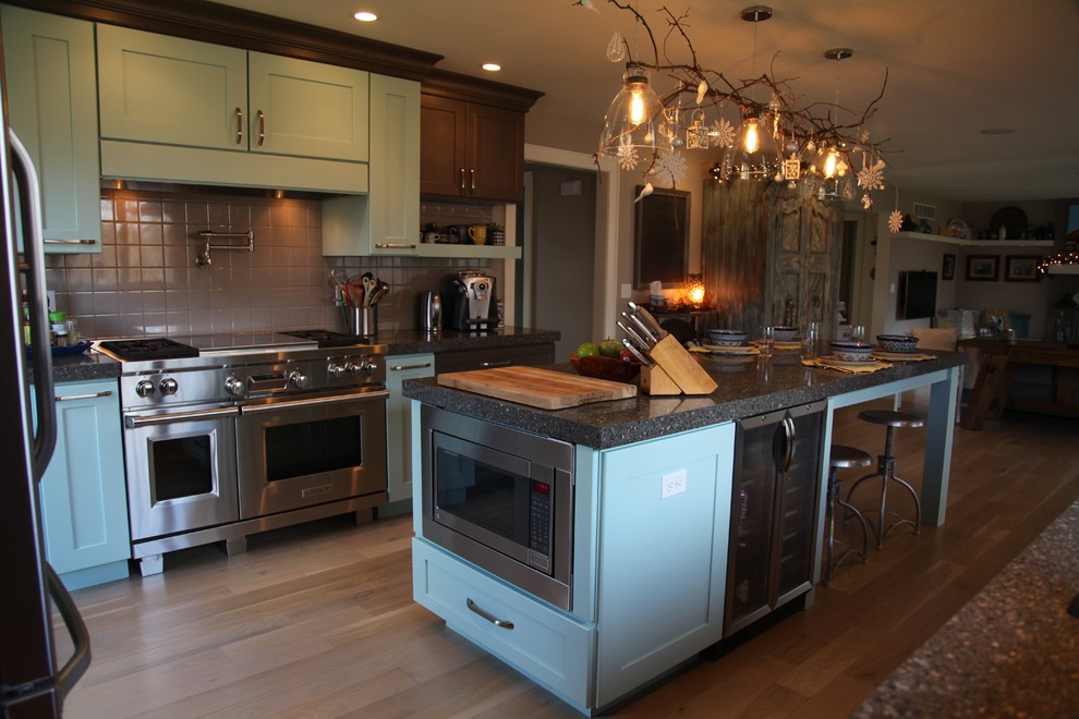 This is an example of a mid-sized eclectic u-shaped eat-in kitchen in Chicago with shaker cabinets, quartz benchtops, stainless steel appliances, with island, blue cabinets and ceramic splashback.