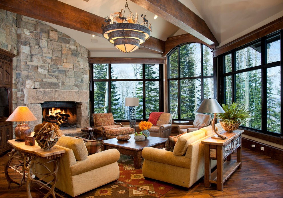 Country open concept living room in Salt Lake City with dark hardwood floors, a corner fireplace, a stone fireplace surround, beige walls and exposed beam.