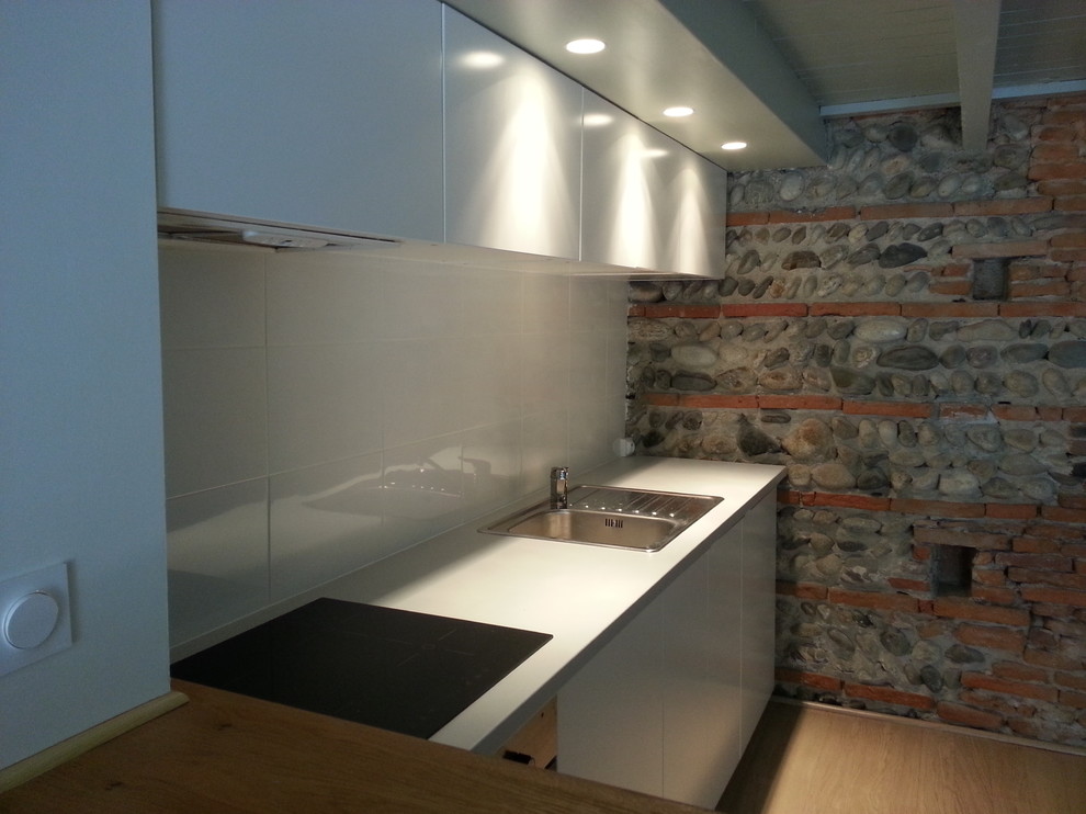 Small scandinavian single-wall eat-in kitchen in Toulouse with a single-bowl sink, beaded inset cabinets, grey cabinets, laminate benchtops, white splashback, ceramic splashback, panelled appliances, light hardwood floors and no island.