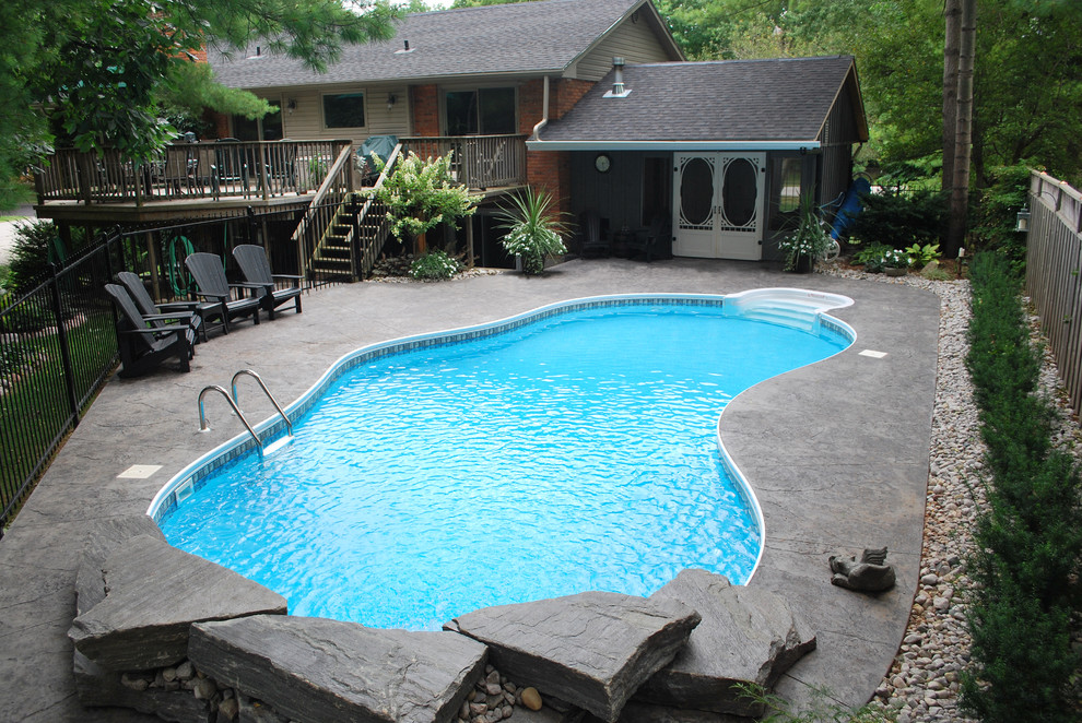 Inspiration for a large traditional backyard custom-shaped pool in Toronto with concrete slab.
