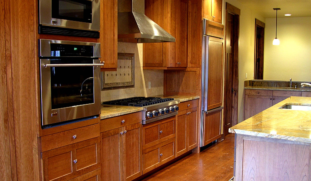 Eat-in kitchen - galley dark wood floor eat-in kitchen idea in Denver with a drop-in sink, medium tone wood cabinets, granite countertops, stainless steel appliances and an island