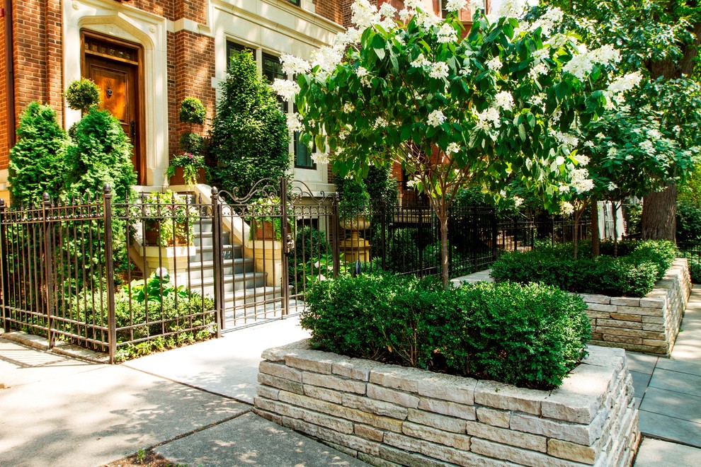 Traditional front yard partial sun garden in Chicago with a garden path and concrete pavers.