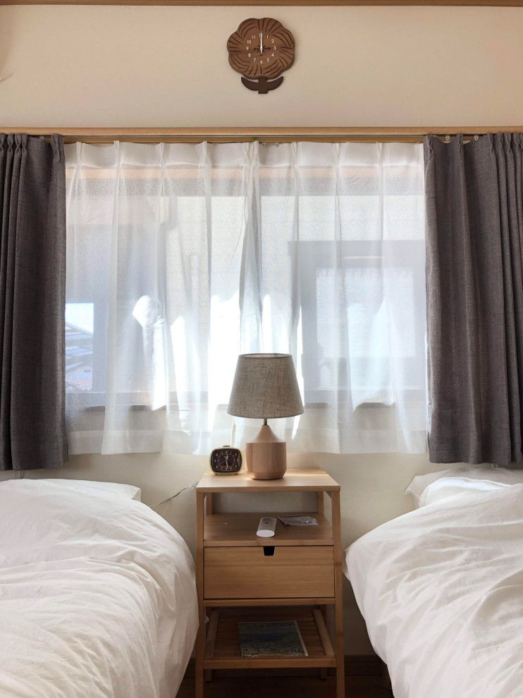 Modelo de habitación de invitados escandinava pequeña sin chimenea con paredes beige, suelo de contrachapado, suelo marrón, papel pintado y papel pintado