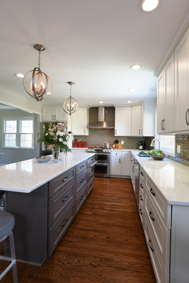 Example of a transitional l-shaped medium tone wood floor eat-in kitchen design in Orange County with a double-bowl sink, shaker cabinets, white cabinets, marble countertops, gray backsplash, glass tile backsplash, stainless steel appliances and an island