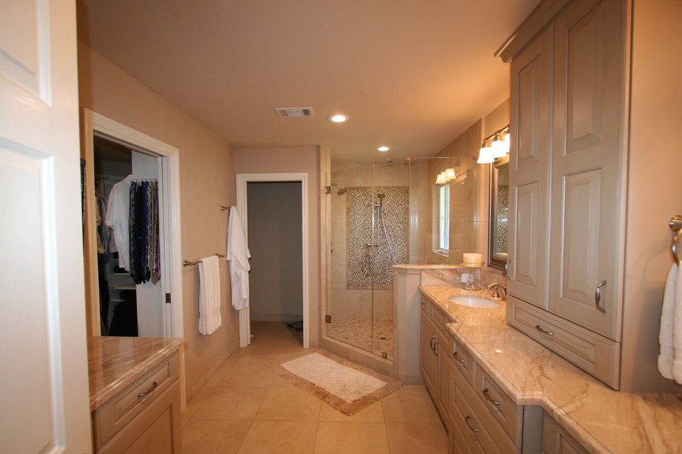 Design ideas for a large traditional master bathroom in San Francisco with an undermount sink, raised-panel cabinets, light wood cabinets, marble benchtops, a corner shower, a one-piece toilet, beige tile, stone tile, beige walls and travertine floors.