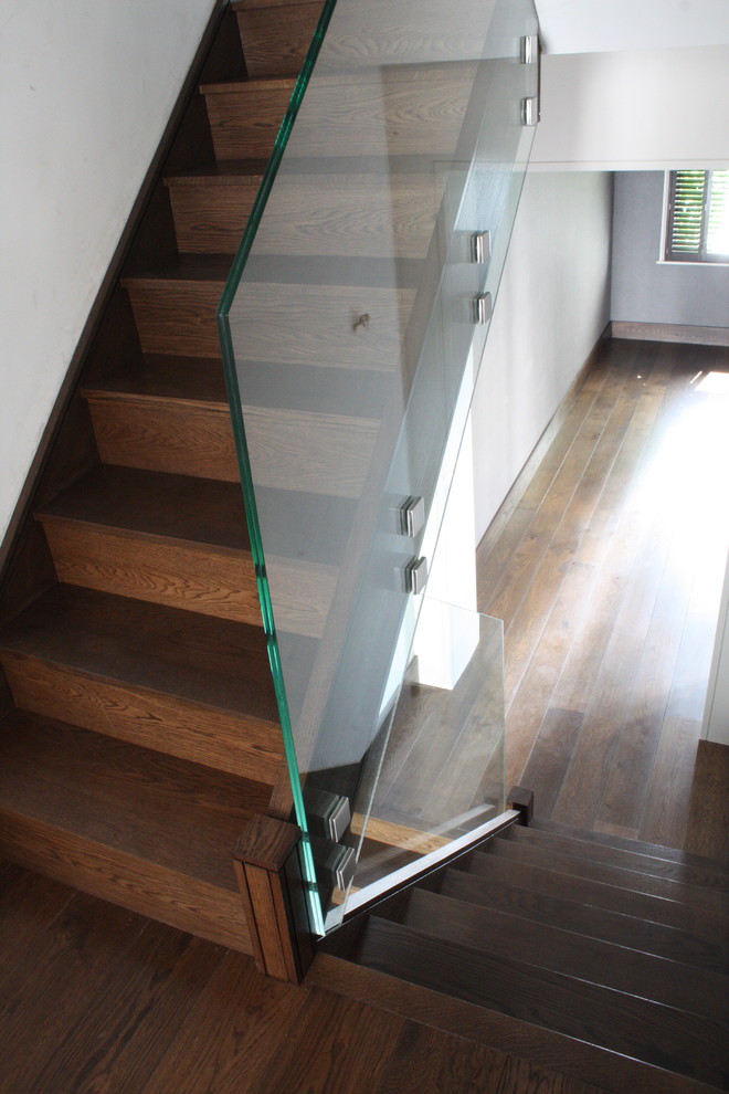 Design ideas for a contemporary wood straight staircase in London with wood risers.