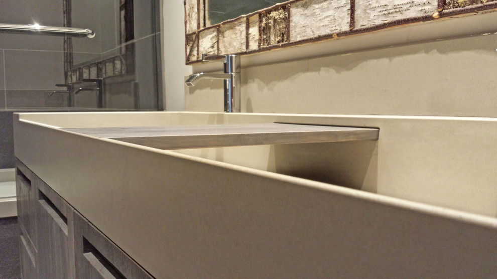 Example of a mid-sized transitional gray tile and ceramic tile bathroom design with an integrated sink, flat-panel cabinets, dark wood cabinets, concrete countertops, an undermount tub and white walls