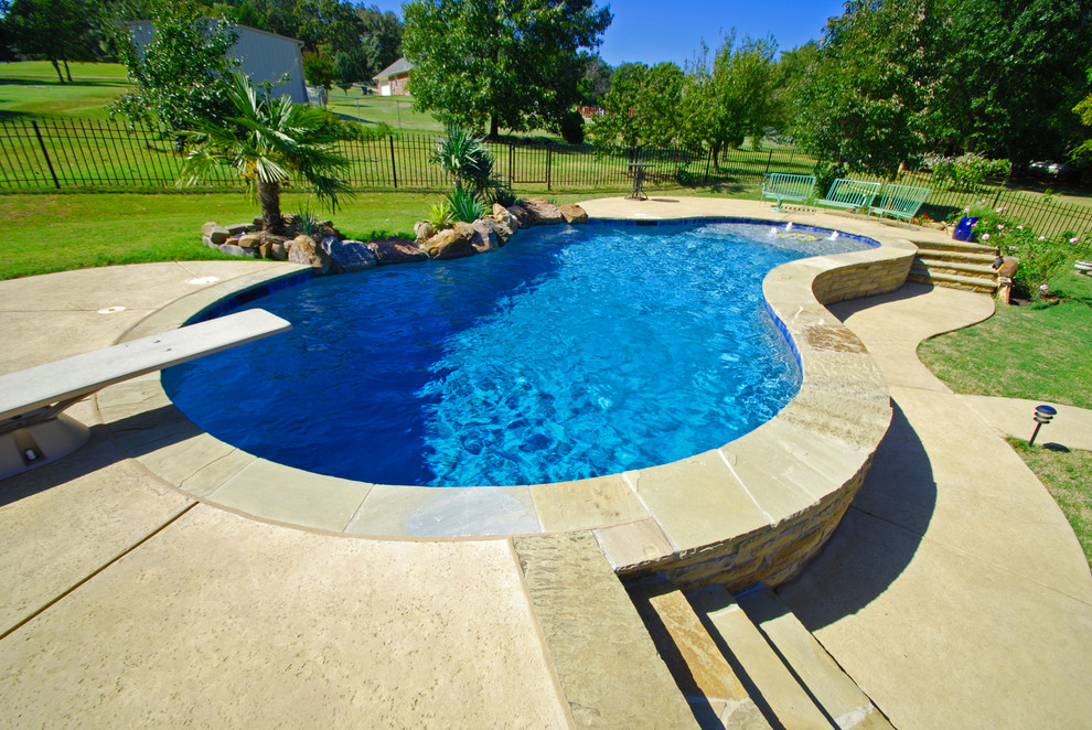 This is an example of a mid-sized country backyard kidney-shaped pool in Austin with stamped concrete.