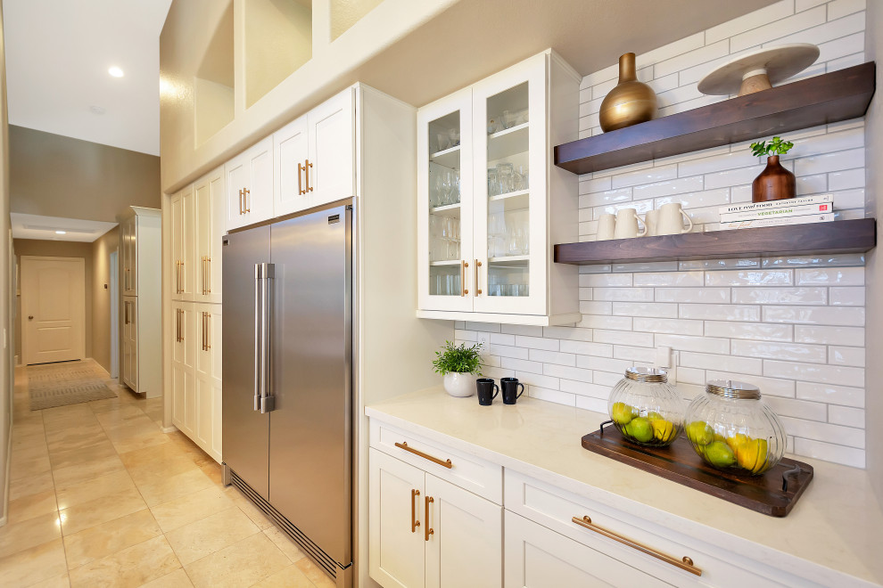 Large transitional u-shaped open concept kitchen photo in Phoenix with a farmhouse sink, shaker cabinets, white cabinets, quartz countertops, white backsplash, subway tile backsplash, stainless steel appliances, an island and white countertops