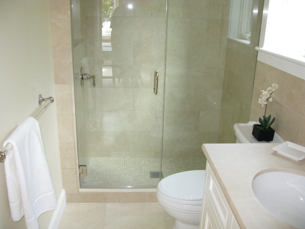 Inspiration for a mid-sized arts and crafts 3/4 bathroom in San Francisco with recessed-panel cabinets, white cabinets, an alcove shower, a two-piece toilet, beige tile, stone tile, beige walls, limestone floors, an undermount sink, limestone benchtops, beige floor and a hinged shower door.