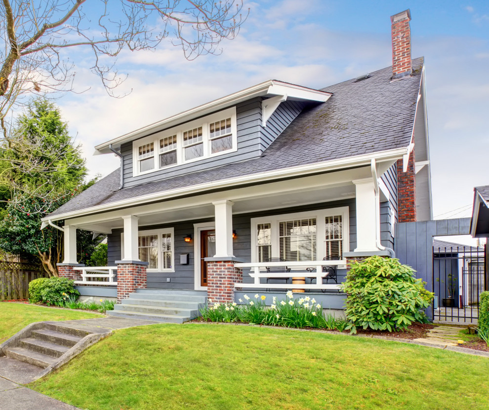 This is an example of an arts and crafts two-storey grey exterior in Seattle with a shingle roof, a grey roof and clapboard siding.
