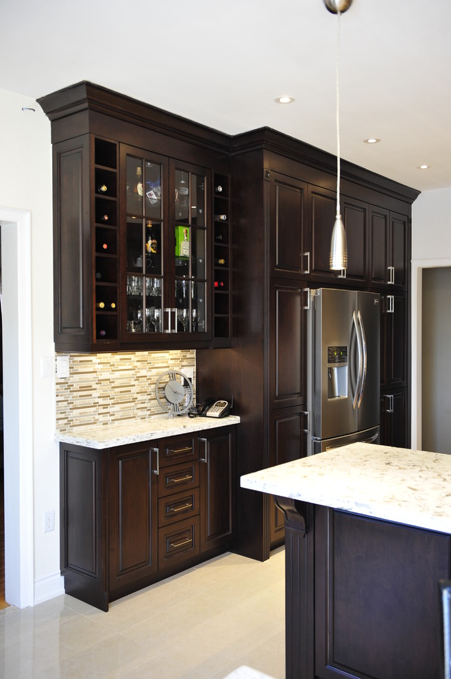Example of a mid-sized transitional u-shaped eat-in kitchen design in Toronto with a double-bowl sink, raised-panel cabinets, dark wood cabinets, quartz countertops, multicolored backsplash, matchstick tile backsplash, stainless steel appliances and a peninsula