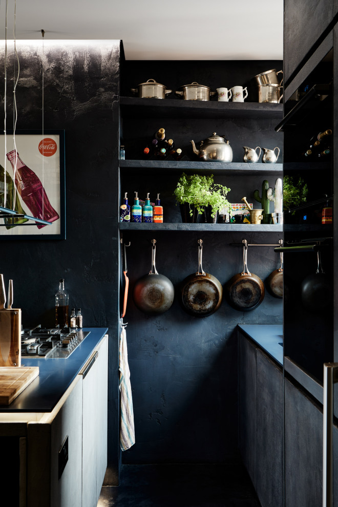 Photo of a small industrial eat-in kitchen in London with flat-panel cabinets, dark wood cabinets, black appliances, with island and blue benchtop.