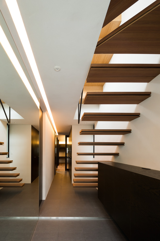 Modern wood l-shaped staircase in Tokyo with open risers.