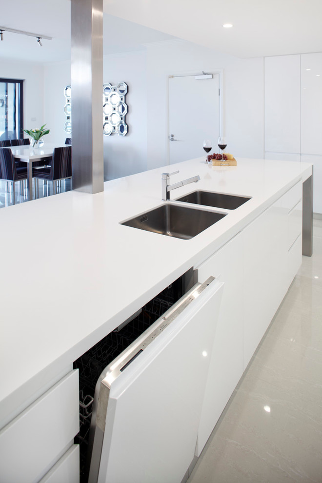 Inspiration for a large contemporary l-shaped eat-in kitchen in Sydney with a drop-in sink, flat-panel cabinets, white cabinets, quartz benchtops, white splashback, stone slab splashback, stainless steel appliances and with island.